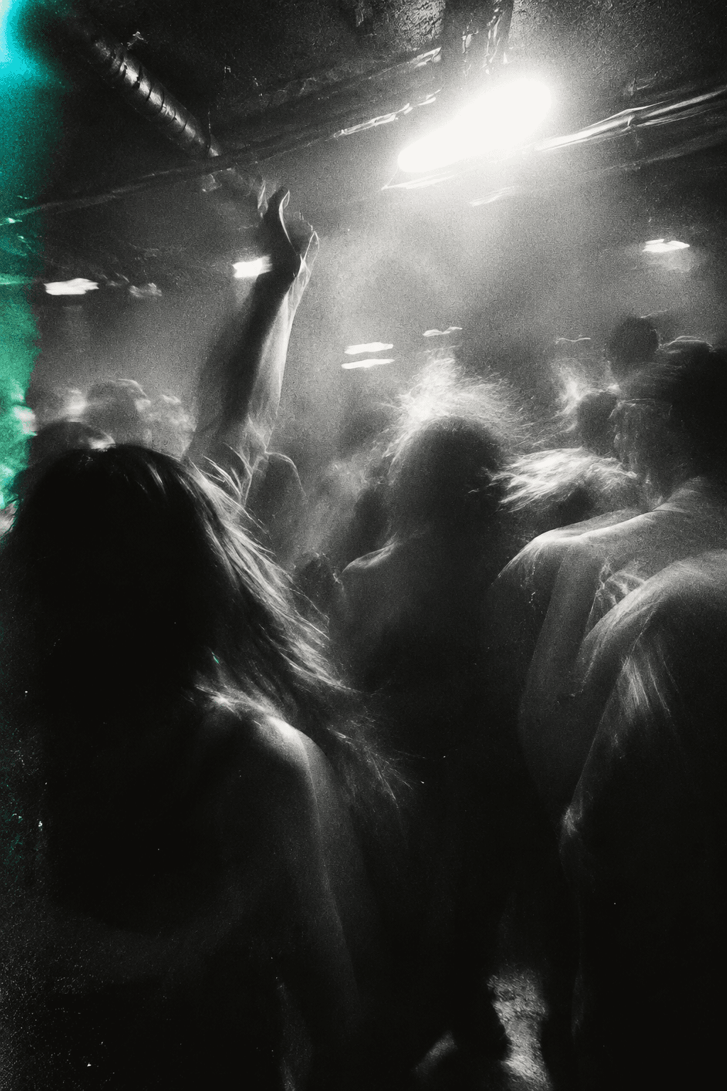 Monochrome dancers moving under a bright club light